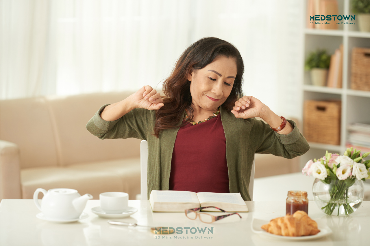 Person stretching at a table.
