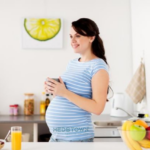 Pregnant woman holding a cup.