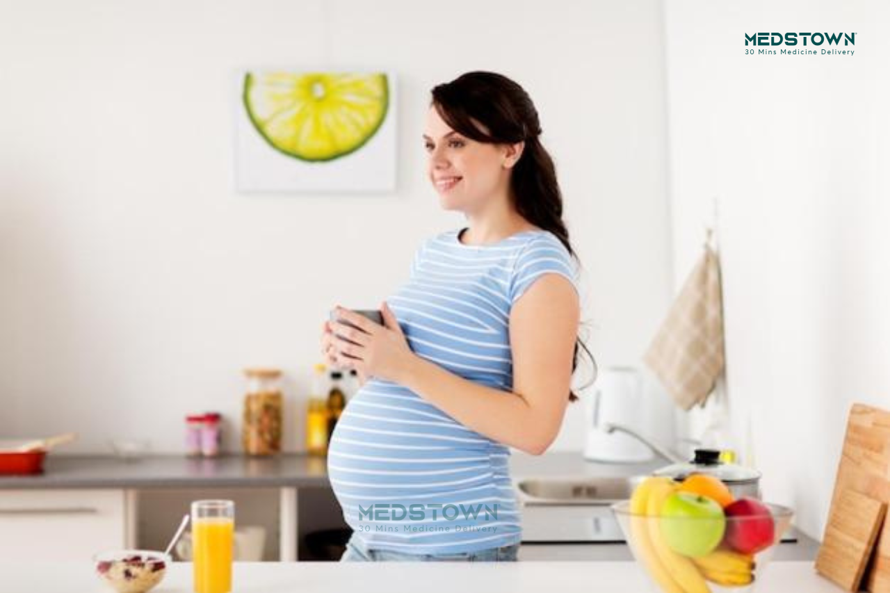 Pregnant woman holding a cup.
