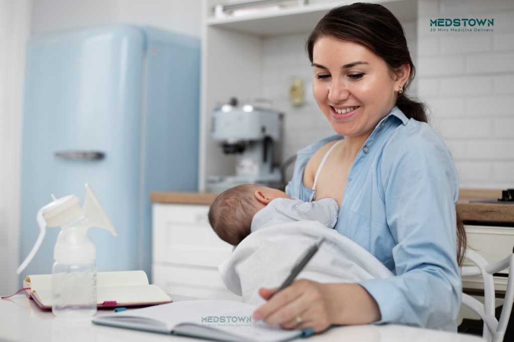 Mother breastfeeding while writing notes.