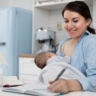Mother breastfeeding while writing notes.